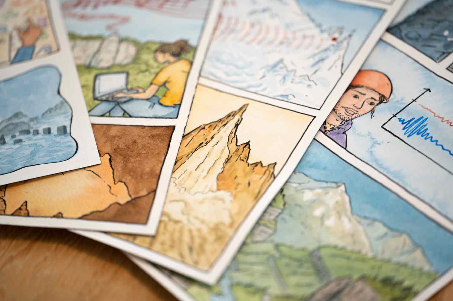 Carnets et planches de bande dessinée sur une table.