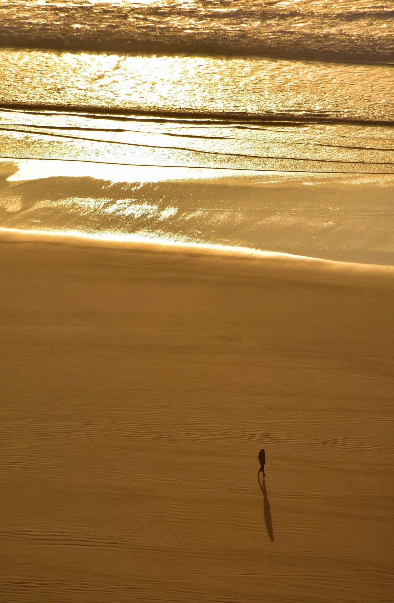 Silhouette sur une plage marocaine au soleil couchant.